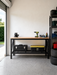 60 inch workbench in a NZ garage with a bench vice, cordless drill and tool boxes on the wire shelf
